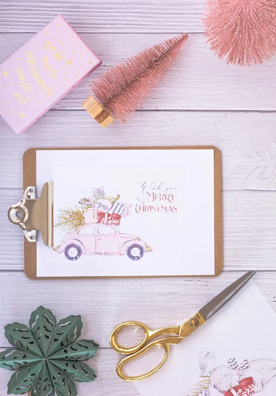 gold scissors beside white greeting card